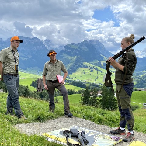 Bild 1 - Der St.Galler Wildhüter Sepp Koller und Jagdaufseher René Schläpfer prüfen eine Jungjägerin im Fach Waffenhandhabung.. Vergrösserte Ansicht